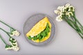 Omelette stuffed with spinach and cheese for a breakfast, with flowers on table Royalty Free Stock Photo