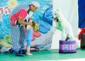 Omer (Beer-Sheva), ISRAEL Clown with a child playing with a white poodle , July 25, 2015