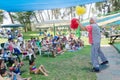 Omer (Beer-Sheva), ISRAEL -Clown plays with children sitting on the grass, July 25, 2015