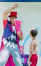 Omer (Beer-Sheva), ISRAEL -Clown throws tennis balls in white cap. Boy looks, July 25, 2015