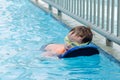 Omer, ISRAEL -Boy in sports glasses floating on the blue board in the pool, July 25, 2015 in Israel