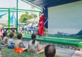 Omer, ISRAEL -Girl gymnast in red kimono jumping with a white ribbon on the green stage in front of the children, July 25, 2015