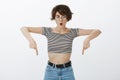 Omg, look down. Portrait of shocked and stunned attractive female with short messy hair in round glasses, saying wow