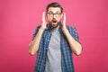 OMG! It`s incredible! Portrait of handsome young man in glasses looking at camera while standing against pink background. Close u Royalty Free Stock Photo