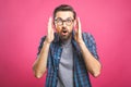 OMG! It`s incredible! Portrait of handsome young man in glasses looking at camera while standing against pink background. Close u Royalty Free Stock Photo