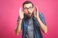 OMG! It`s incredible! Portrait of handsome young man in glasses looking at camera while standing against pink background. Close u Royalty Free Stock Photo