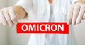 Omicron red warning sign with text new Omicron variant covid 19 in doctor hands in white coat and gloves. Long web Royalty Free Stock Photo