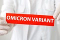 Omicron variant text lettering red warning sign. New Omicron variant covid 19 in doctor hands in white coat and gloves. Royalty Free Stock Photo