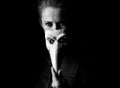 Woman isolated on black hiding behind Venetian mask