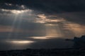 Ominous clouds and the bursting rays of light over the gulf sea