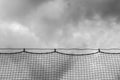 Ominous clouds viewed through baseball netting