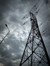 Ominous, dramatic photo of a wire support column, high voltage electric lines and a non-illuminating public lamp