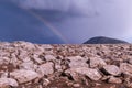 Ominous, overcast sky looms above a barren rocky field