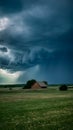 Ominous storm brews over rural farm in dramatic sky