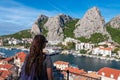 Omis - Tourist woman looking at coastal town Omis surrounded by Dinara mountains in Split-Dalmatia, Croatia, Europe Royalty Free Stock Photo
