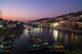 Omkareshwar cityscape at dusk, India, sacred hindu temple. Holy Narmada River, boats floating. Travel destination for tourists and