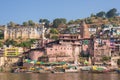 Omkareshwar cityscape, India, sacred hindu temple. Holy Narmada River, boats floating. Travel destination for tourists and pilgrim