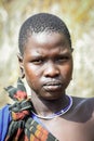 Close up Portrait of Young African Woman with the cut hair in the local Mursi tribe village