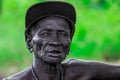 Portrait of Blind African Old Man siting on the ground and posing for the tourists in the local Mursi tribe village