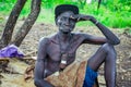 Portrait of Blind African Old Man siting on the ground and posing for the tourists in the local Mursi tribe village