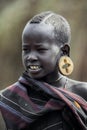 Portrait of Brave African Young Boy with a big traditional wooden earrings with the Crosses in the local Mursi tribe village Royalty Free Stock Photo