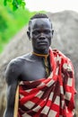 Portrait of Serious and Brave African Man in Traditional dress and Wooden Stick in the local Mursi tribe village
