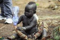 Omo River Valley, Ethiopia, November 2020, A small child from the Mursi tribe sits on the ground Royalty Free Stock Photo