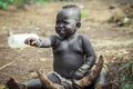 Omo River Valley, Ethiopia, November 2020, A small child from the Mursi tribe sits on the ground Royalty Free Stock Photo