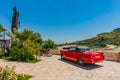 Omodos, Cyprus - June 7, 2018: Colorful scene of a resort island in the Troodos Mountains. Beautiful red car and a red motorcycle