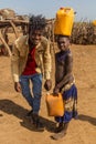 OMORATE, ETHIOPIA - FEBRUARY 5, 2020: City-dweller visiting Daasanach tribe in their village near Omorate, Ethiop