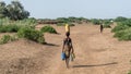 Unidentified woman from Dassanech tribe carrying water to her village, Ethiopia