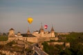 Striped hot air balloon flying over city.