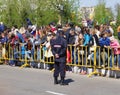 Omsk, Russia - May 09, 2014: public event, crowd of people behind fence and policeman