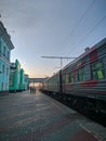 Omsk, Russia - May 16, 2020: The train stopped on the platform. Sunset sky. Vertical