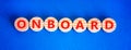 Onboard and onboarding symbol. The concept word Onboard on wooden circles. Beautiful blue background, copy space. Business onboard