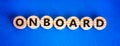 Onboard and onboarding symbol. The concept word Onboard on wooden circles. Beautiful blue background, copy space. Business onboard