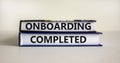 Onboarding completed symbol. Books with words `Onboarding completed`. Beautiful white background. Business, onboarding completed