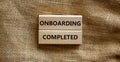 Onboarding completed symbol. Wooden blocks with words `Onboarding completed`. Beautiful canvas background. Business, onboarding