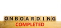 Onboarding completed symbol. Words `Onboarding completed` on wooden cubes. Business and onboarding completed concept. Beautiful