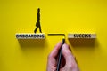 Onboarding success symbol. Wooden blocks with words `onboarding success`. Businessman hand. Businesswoman icon. Beautiful yellow