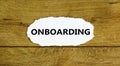 Onboarding success symbol. The word `Onboarding` on white paper. Beautiful wooden background. Business, onboarding success conce