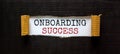 Onboarding success symbol. Words `Onboarding success` appearing behind torn black paper. Beautiful black background. Business,