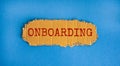 Onboarding symbol. The concept word `onboarding` on the piece of cardboard. Beautiful blue background, copy space. Business and