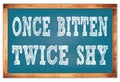 ONCE BITTEN TWICE SHY words on blue wooden frame school blackboard