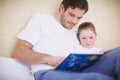 Once upon a time...A devoted father reading his young daughter a bedtime story.