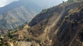 The once vibrant green mountainsides now barren and scarred with deep gashes from the landslide. The devastating impact