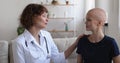 Oncologist doctor talking to female patient during home visit