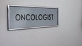 Oncologist room door desk closeup, patient consulting, cancer risk prevention