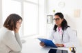 Doctor with pink awareness ribbon and sad patient Royalty Free Stock Photo