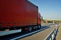 Oncoming red trucks on empty highway in the countryside Royalty Free Stock Photo